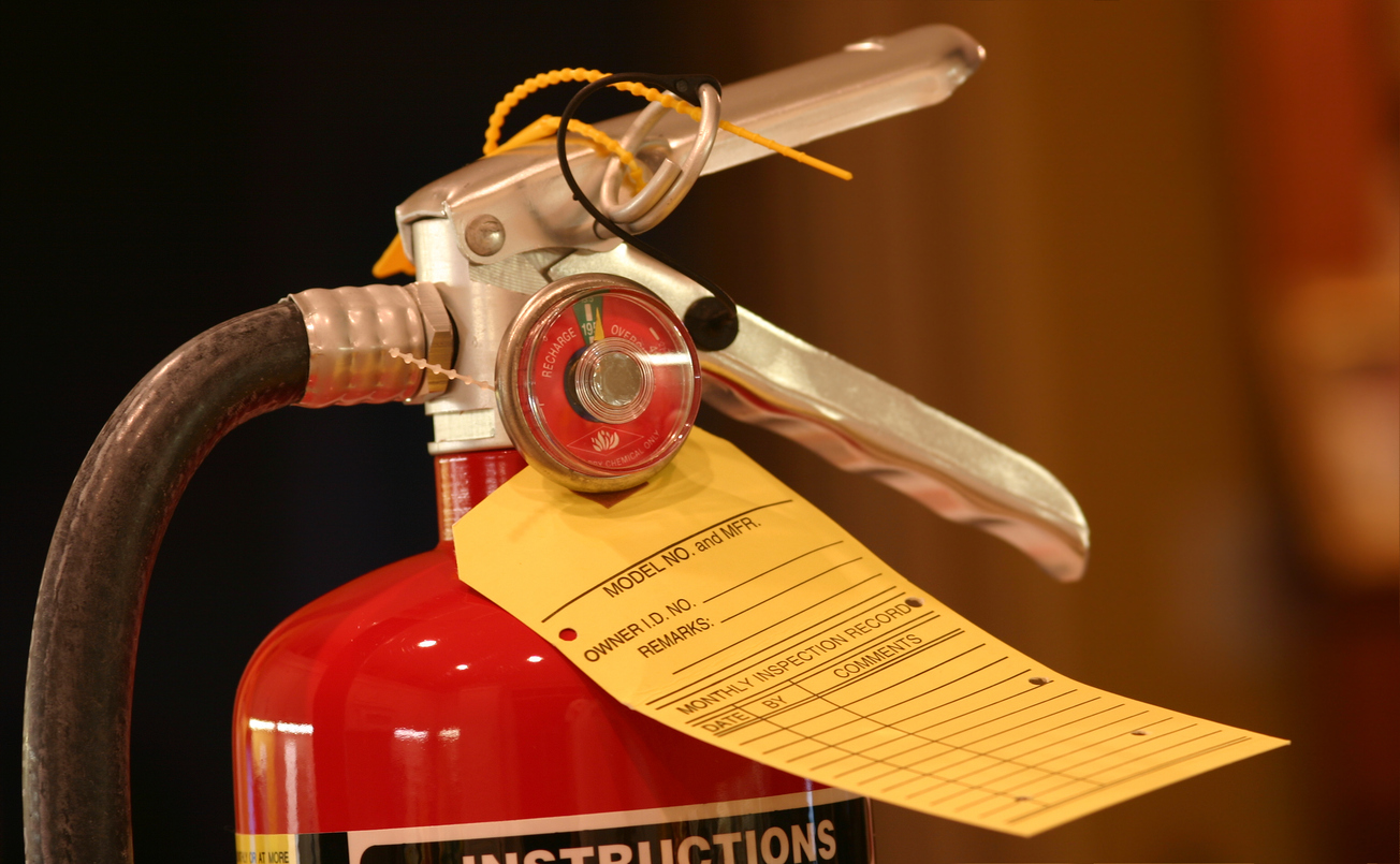 Photo of a fire extinguisher with a blank inspection tag.